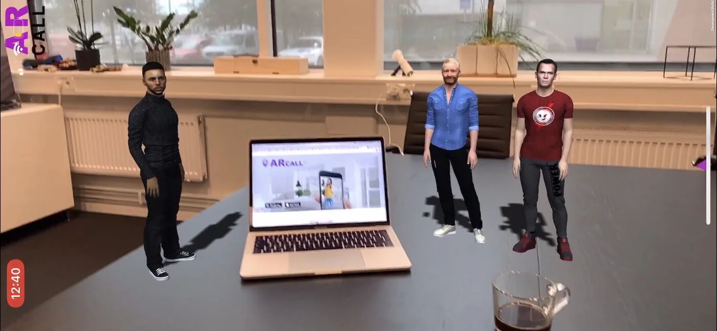 Group meeting avatars shown on a desk in AR